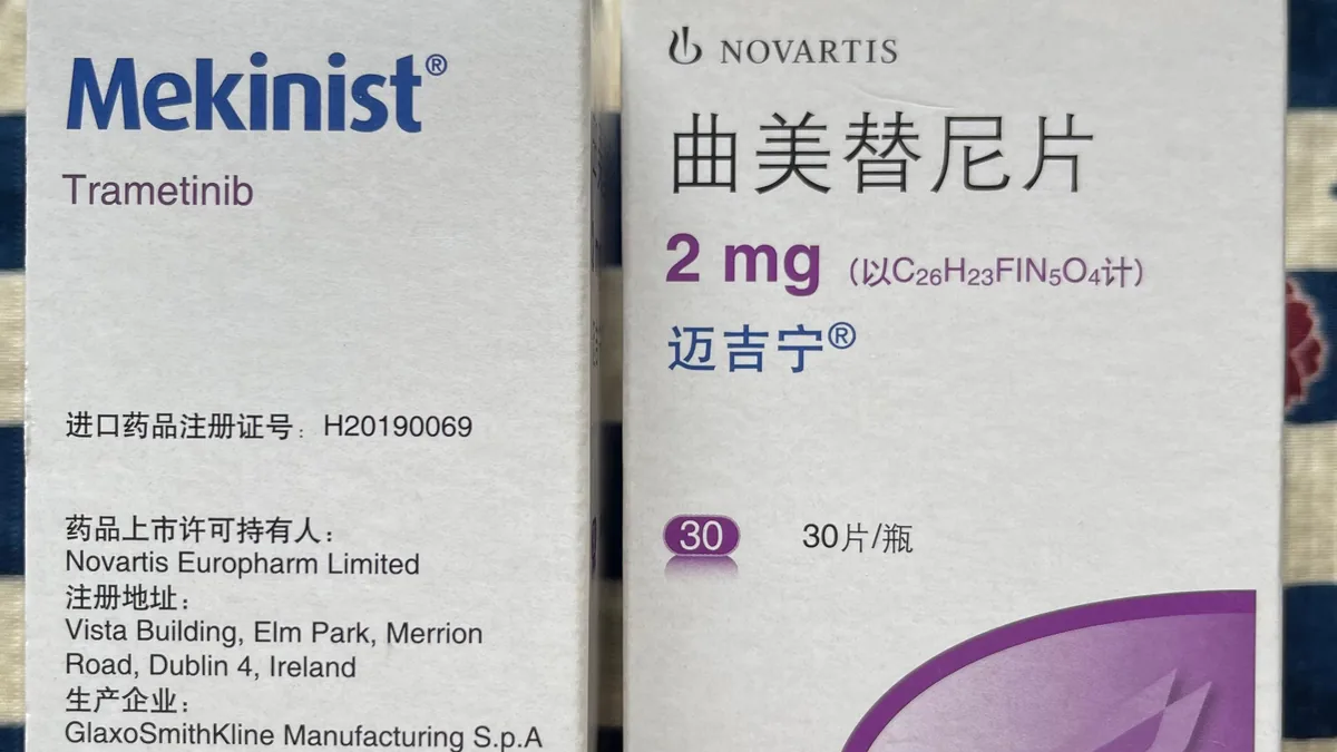 患者手持体温计和药盒，记录发热情况，旁边有笔记本和笔